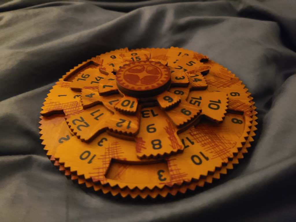 Five laser-cut wooden discs, irregularly shaped, with numbers on them.